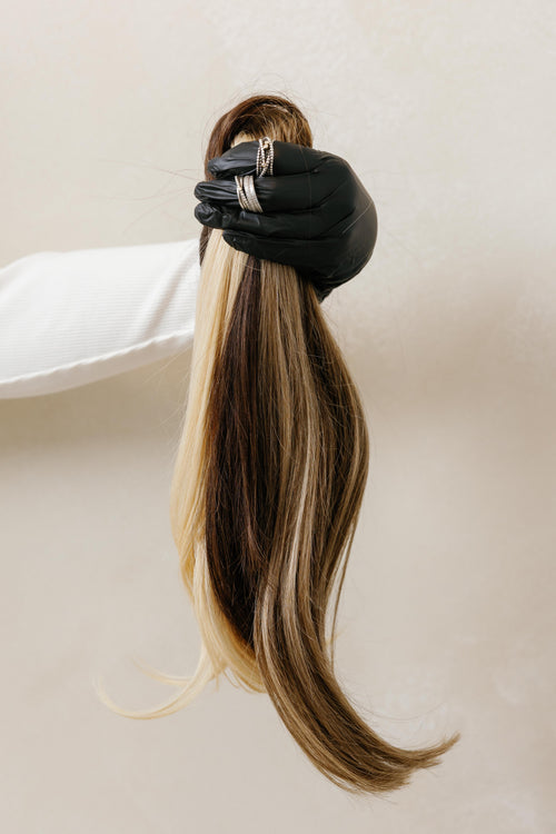 Extensión de cabello multitón en rubio y castaño, detalle de textura sostenida en mano - Popa Emperifolla Beauty Studio