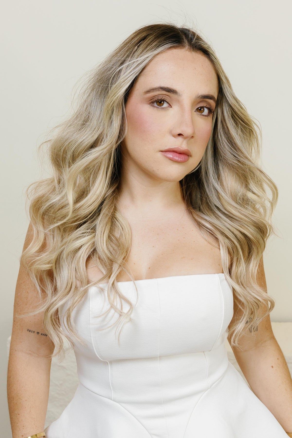 Mujer con extensiones de cabello balayage rubio y castaño, look ondulado natural - Popa Emperifolla Beauty Studio