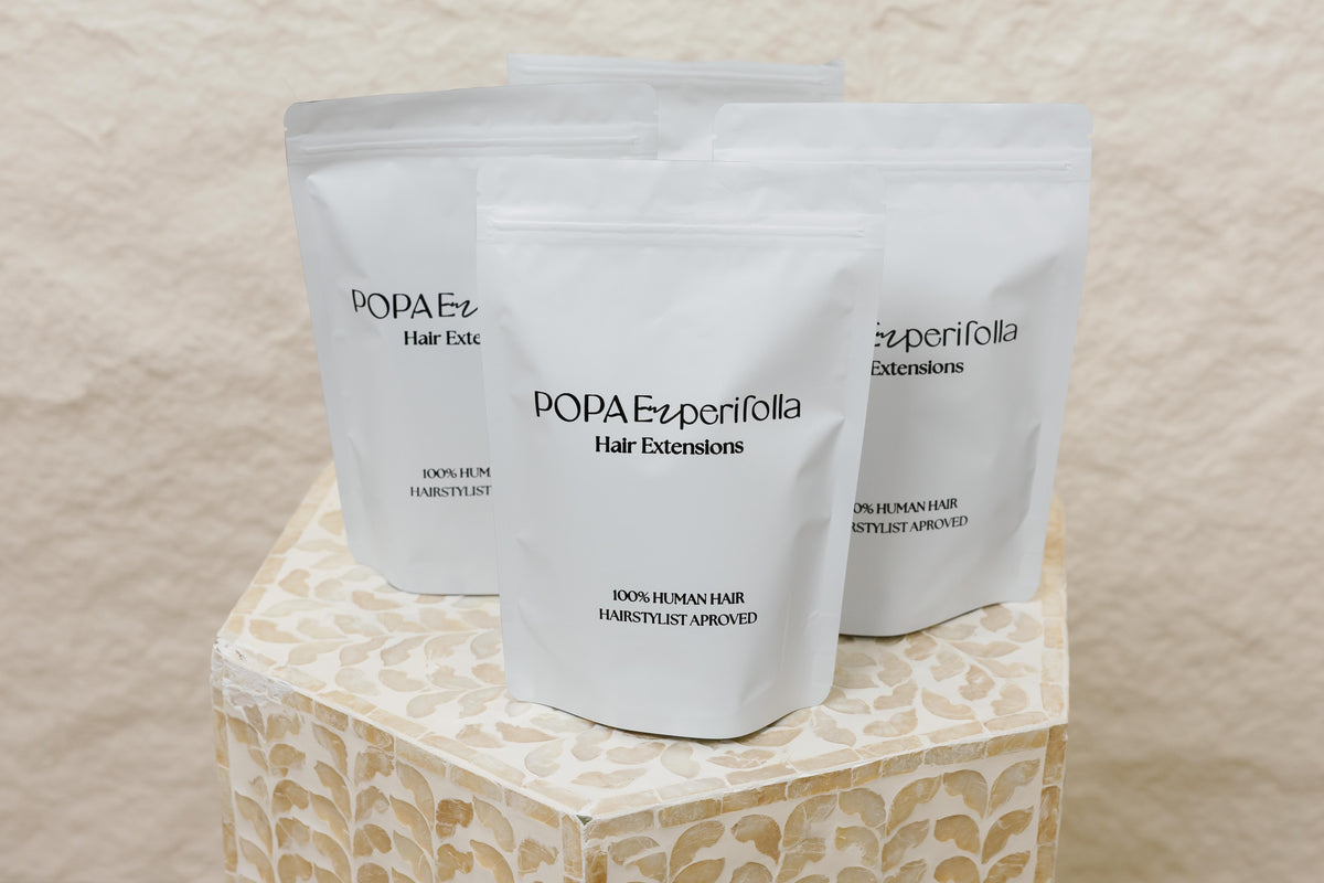 Primer plano de empaques de extensiones de cabello 100% humano Popa Emperifolla - Popa Emperifolla Beauty Studio