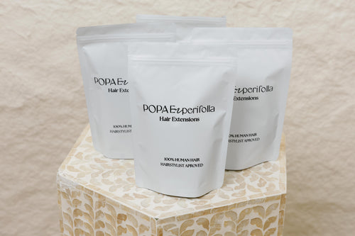 Primer plano de empaques de extensiones de cabello 100% humano Popa Emperifolla - Popa Emperifolla Beauty Studio